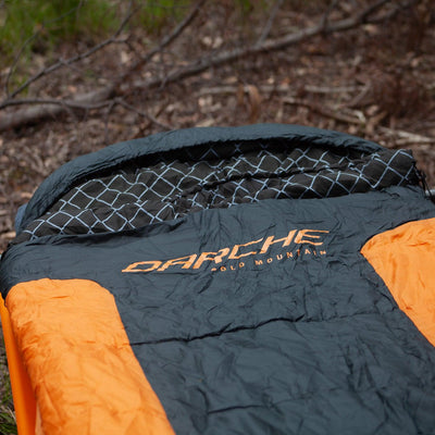 DARCHE Cold Mountain Canvas sleeping bag unrolled inside a camping swag, showing the dual zip entry system and shaped hood